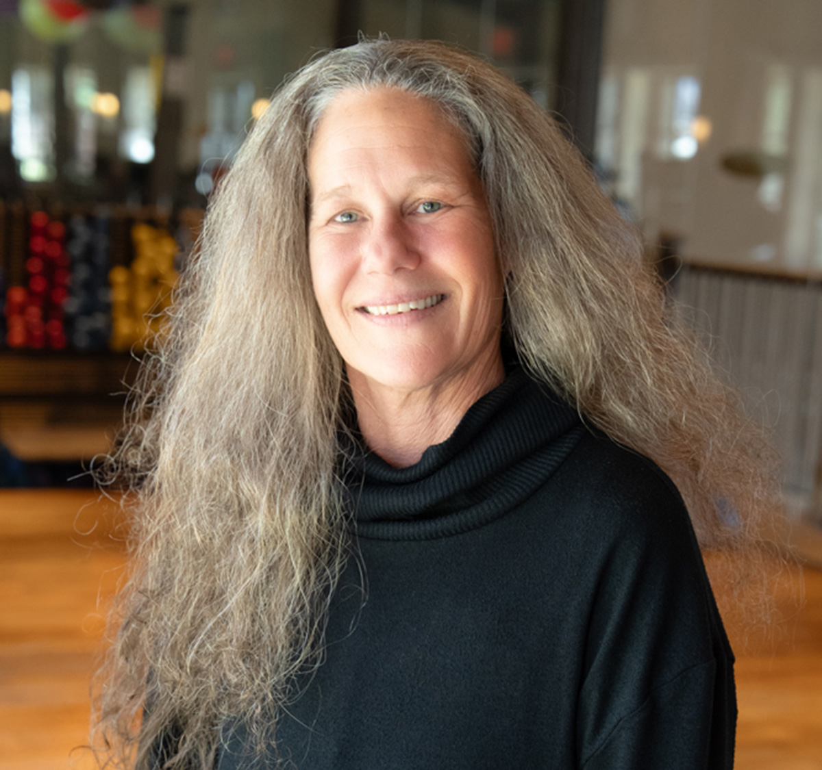 a woman with long gray hair smiling