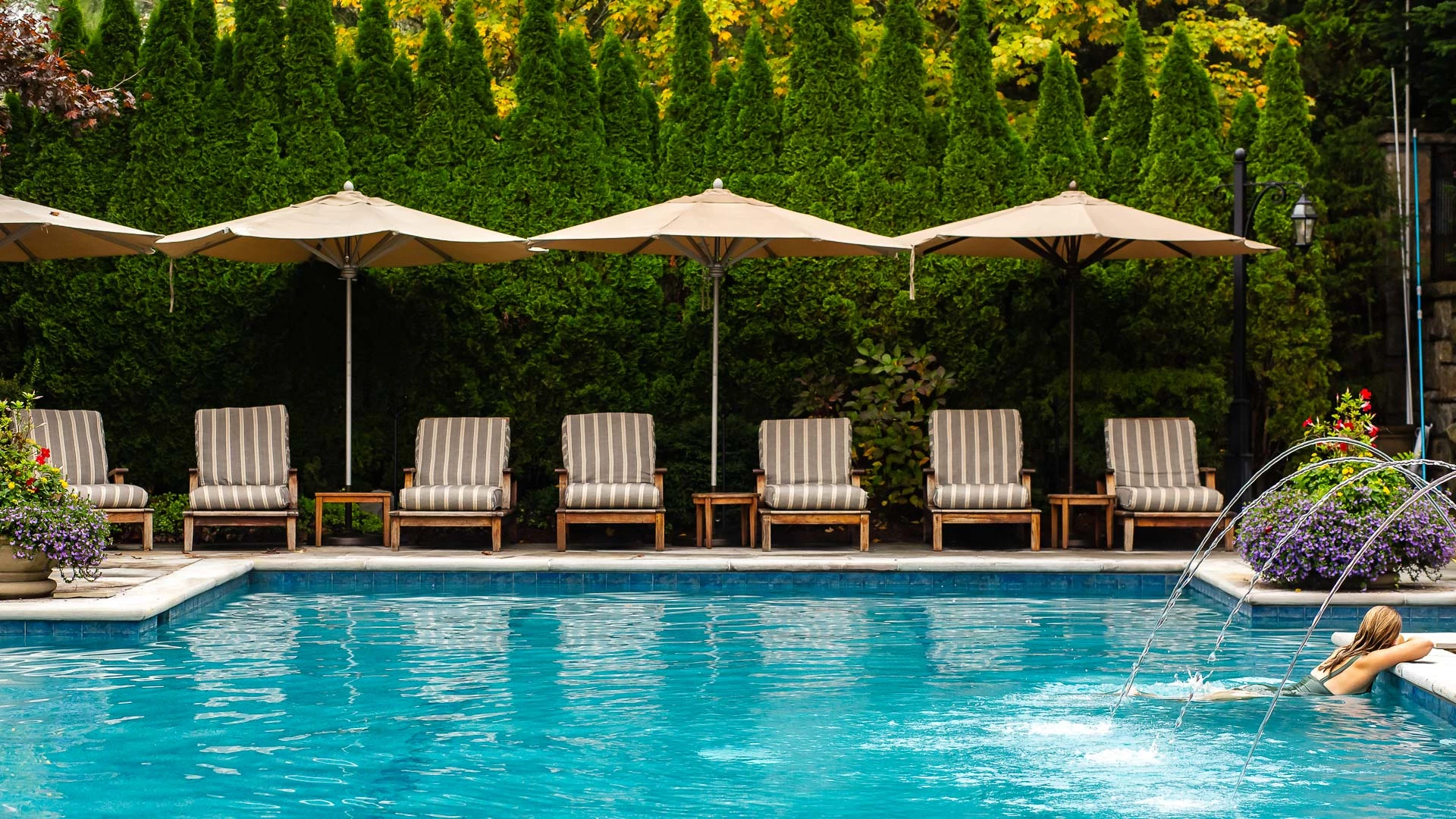 a pool with chairs and umbrellas