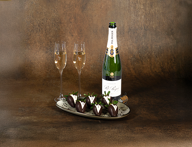 a bottle of champagne and chocolate covered strawberries
