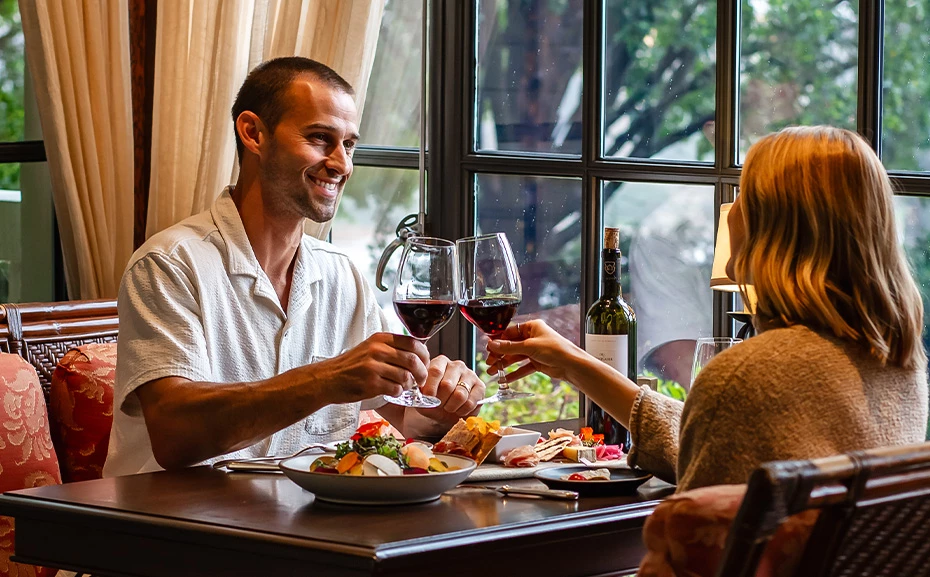 a man and woman sitting at a table with wine glasses