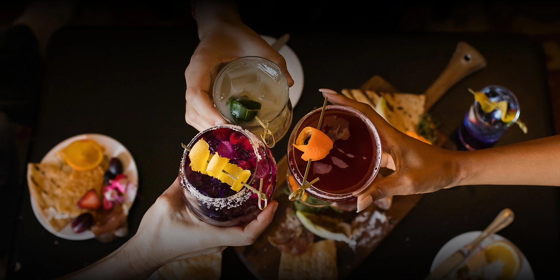 a group of hands holding drinks