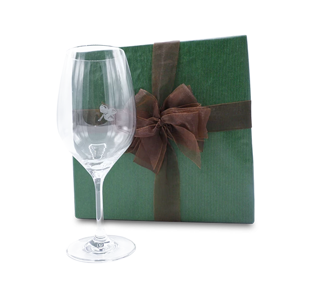a glass next to a gift box
