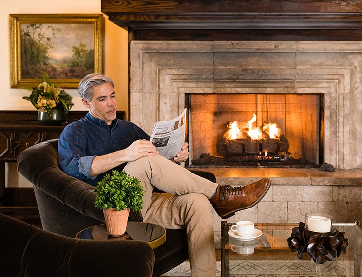 a man sitting in a chair reading a newspaper