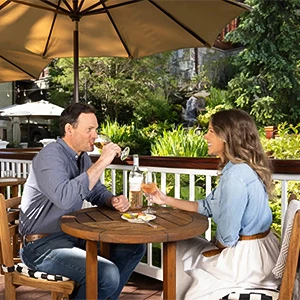 a man and woman sitting at a table drinking wine