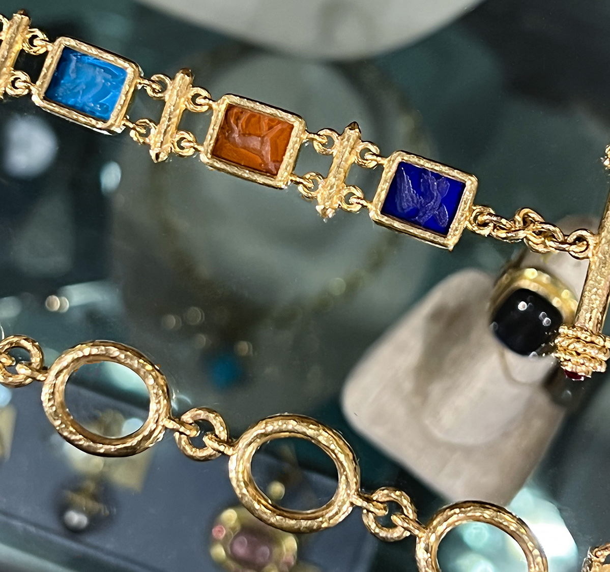 a gold bracelet with colorful stones