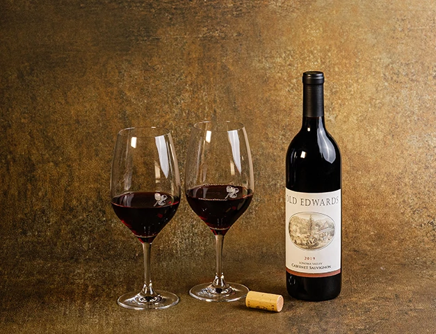 a bottle of wine next to two wine glasses