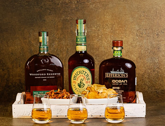 a group of bottles of liquor and a tray of glasses