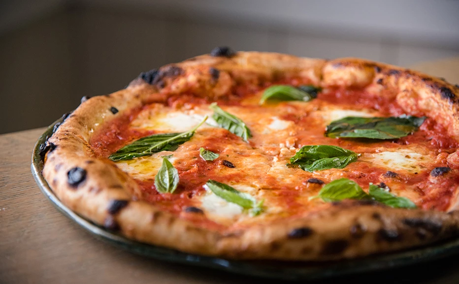 a pizza with basil on it