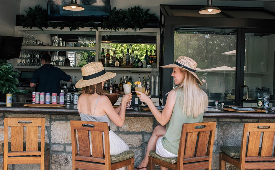 two women sitting at a bar with drinks