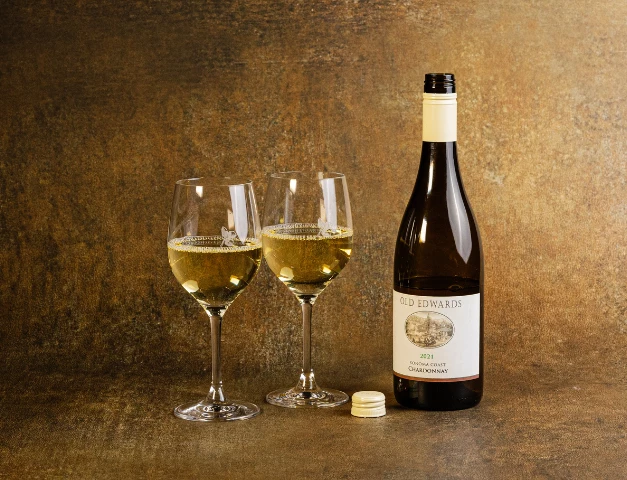 a bottle of wine next to two wine glasses