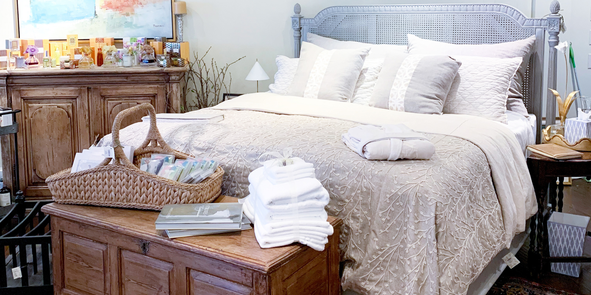 a bed with a basket of books and towels