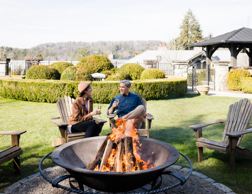 a man and woman sitting around a fire pit
