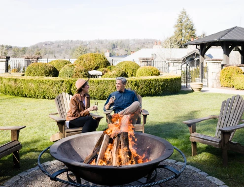 a man and woman sitting around a fire pit