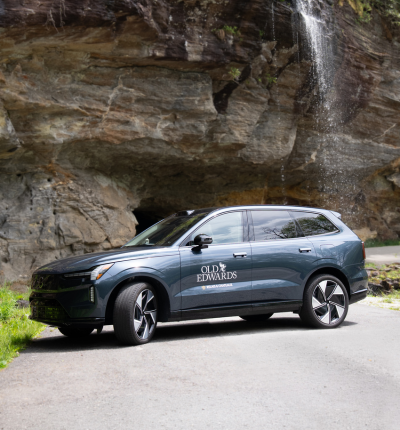 a car parked on a road near a waterfall