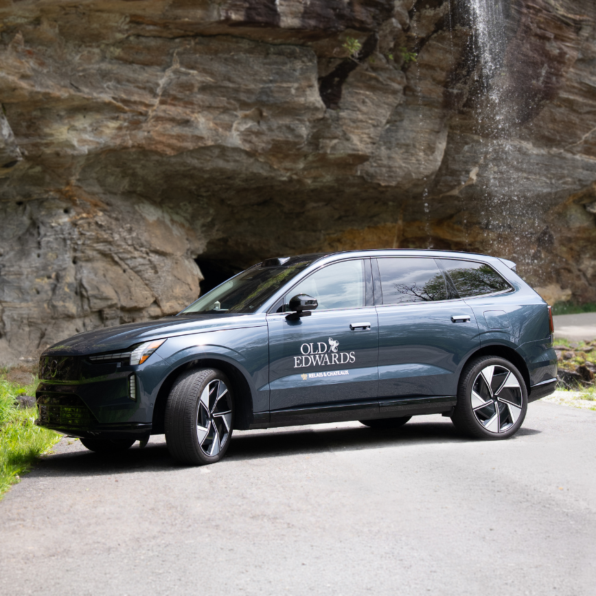 a car parked on a road near a waterfall