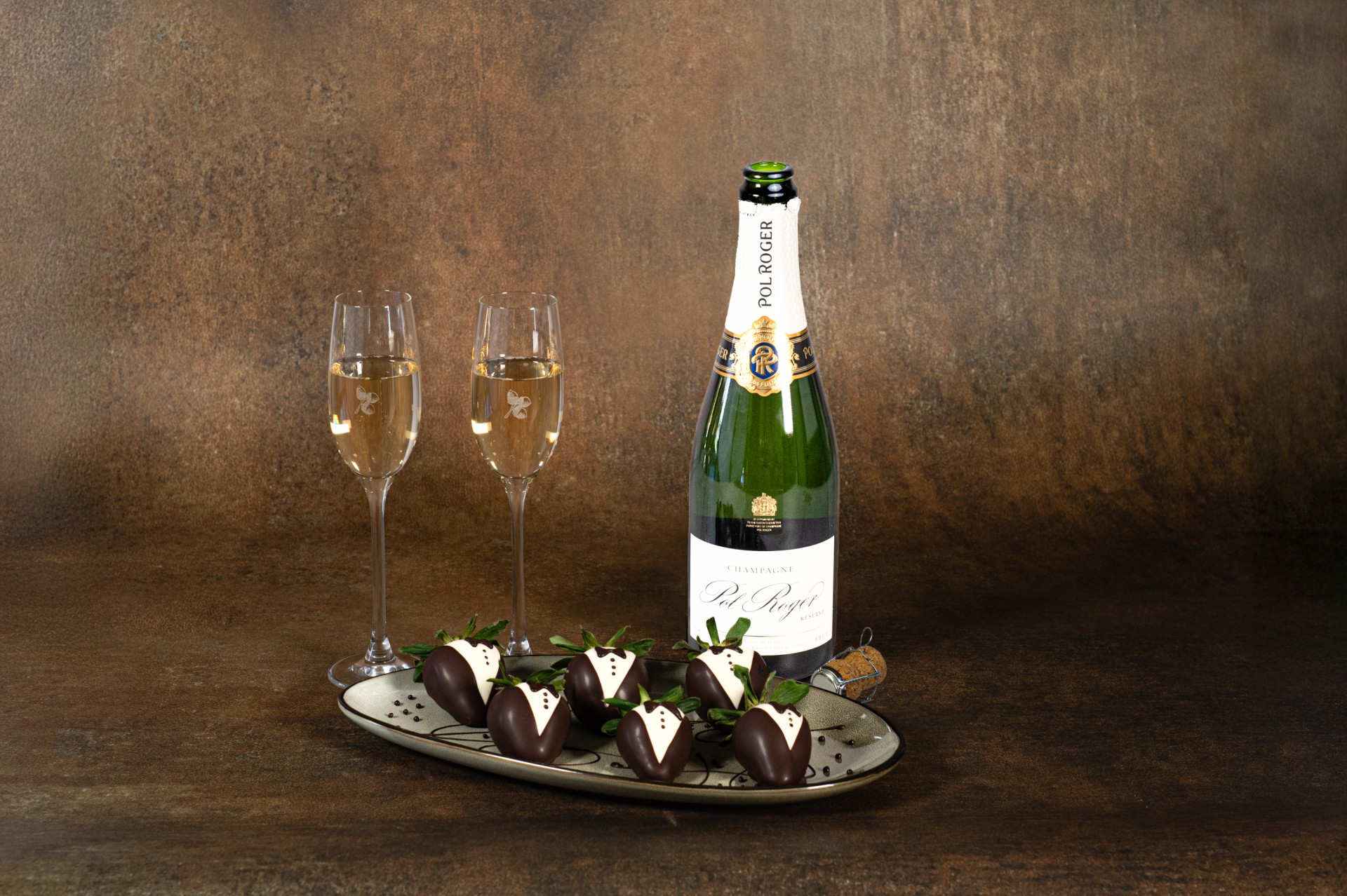 a bottle of champagne and chocolate covered strawberries