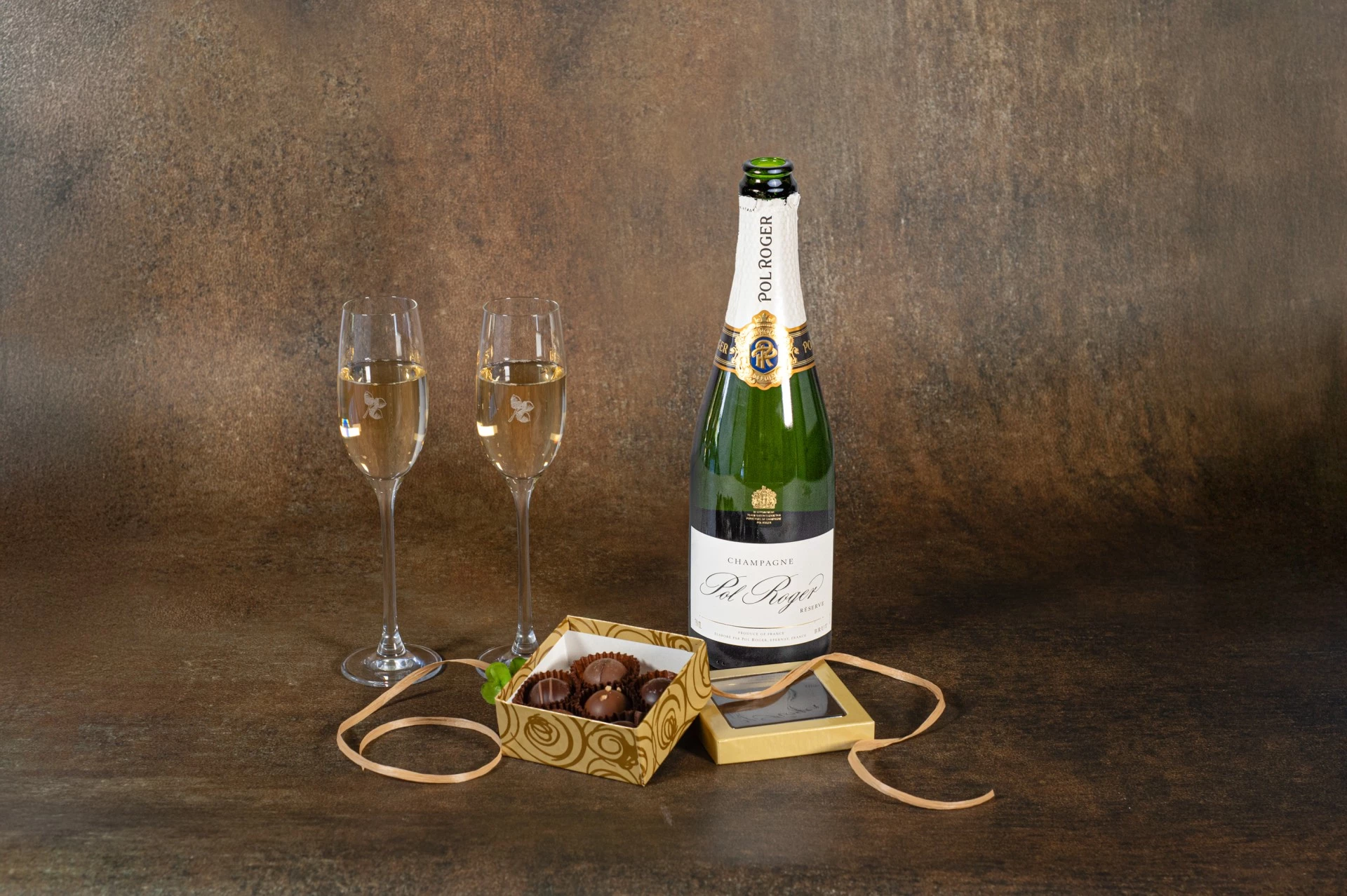 a bottle of champagne next to two glasses of chocolate