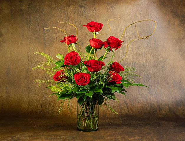 a bouquet of red roses in a glass vase