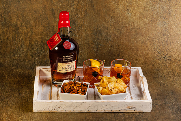 a tray with a bottle of alcohol and snacks