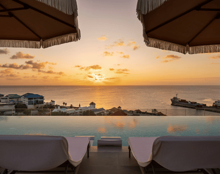 a pool with a view of the ocean and a city in the distance