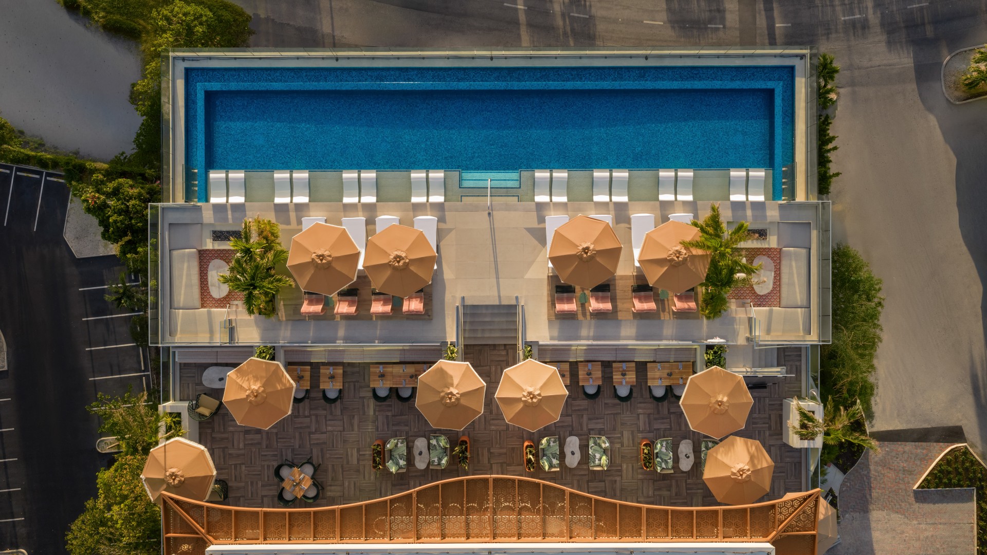 an aerial view of a pool with umbrellas and chairs