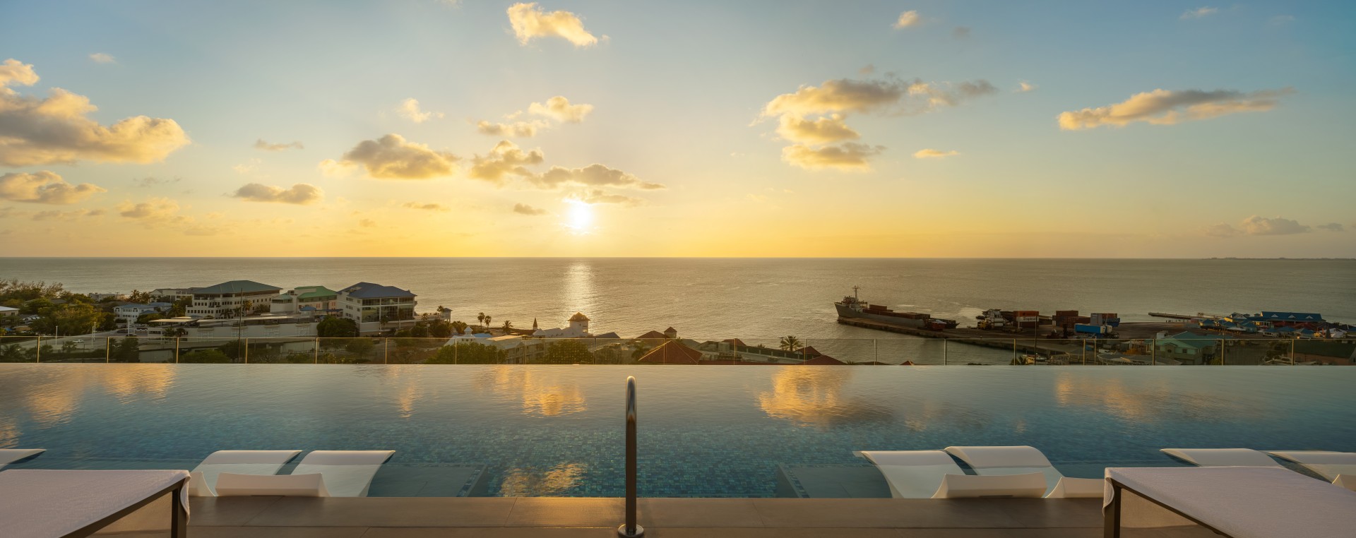 a pool with a view of the ocean and a ship in the distance