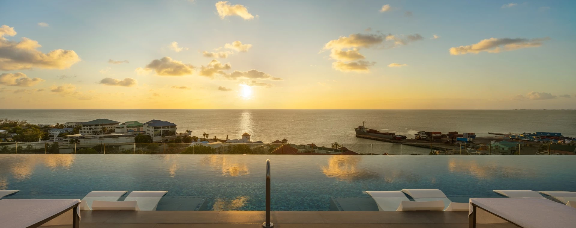 a pool with a view of the ocean and a ship in the distance