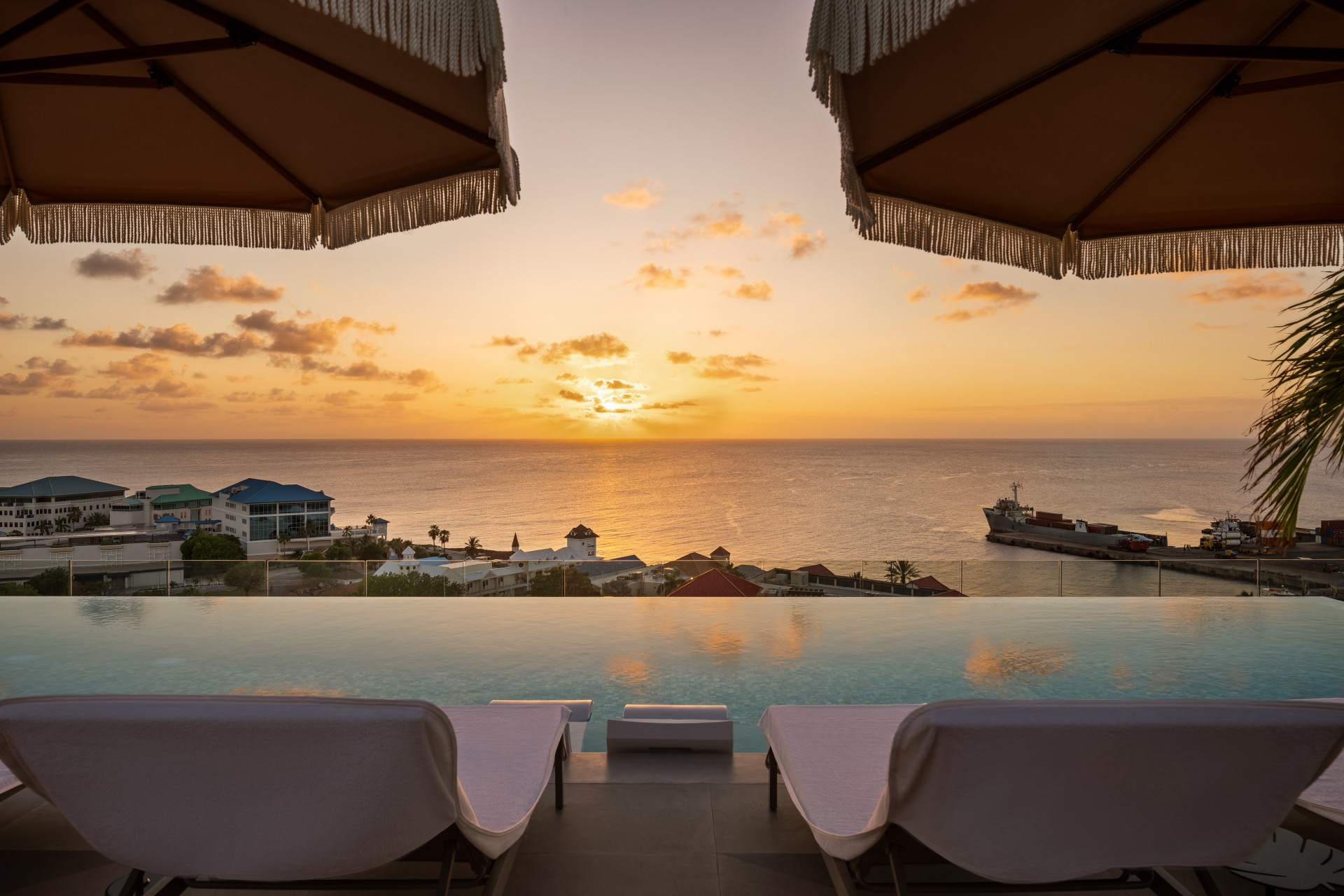 a pool with a view of the ocean and a city in the distance