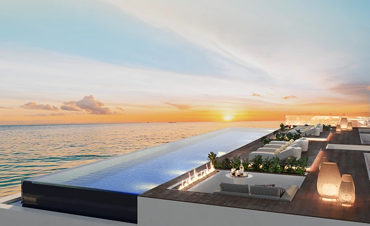 a pool with lounge chairs and a sunset