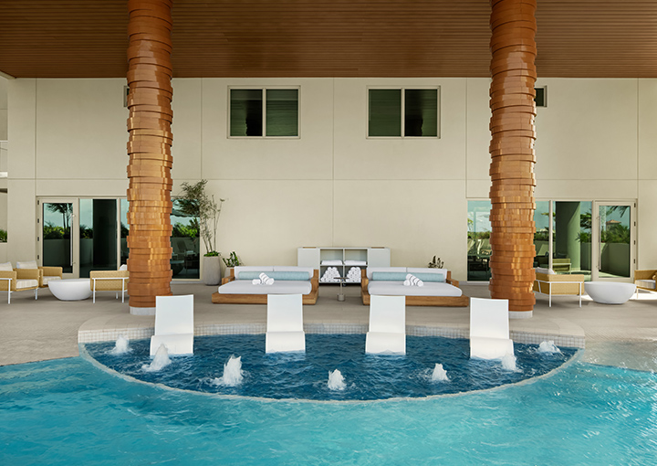 a pool with a large fountain and chairs