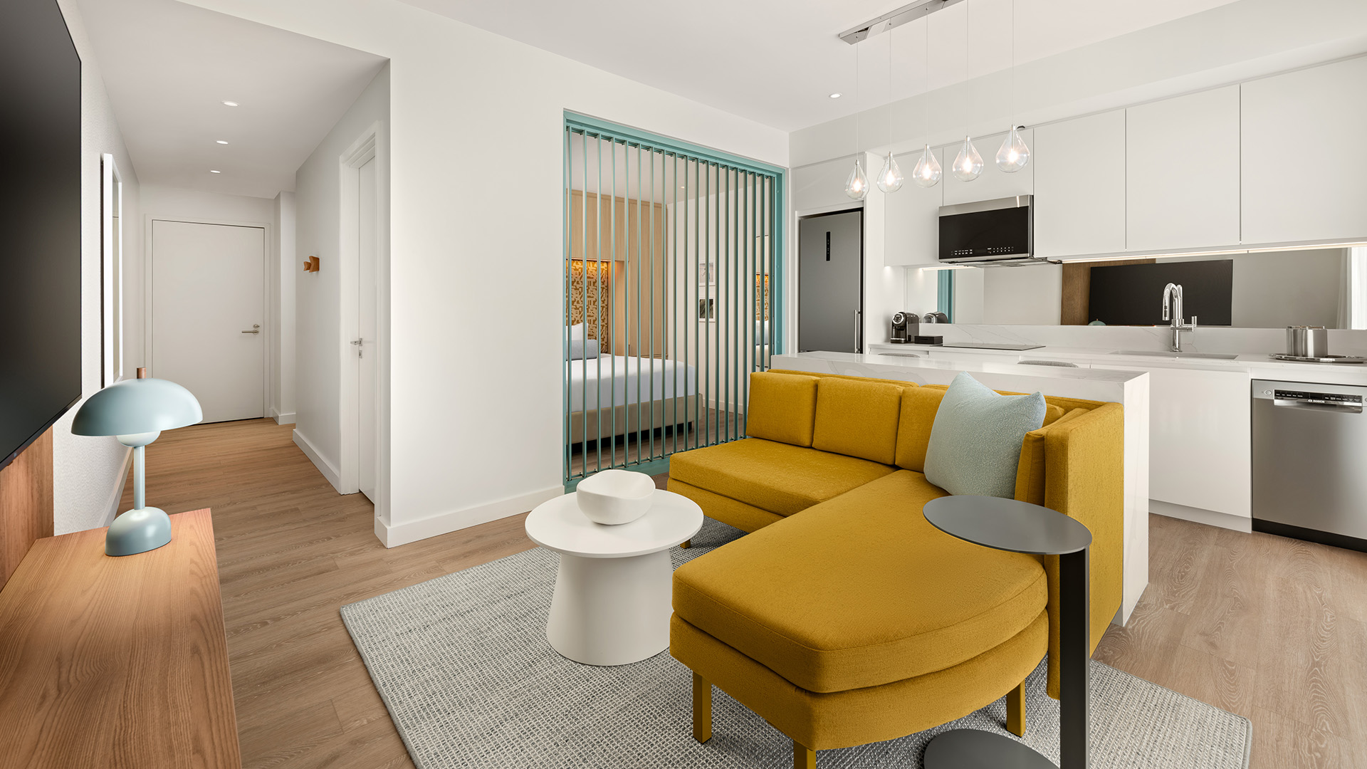a living room with a yellow couch and a white table