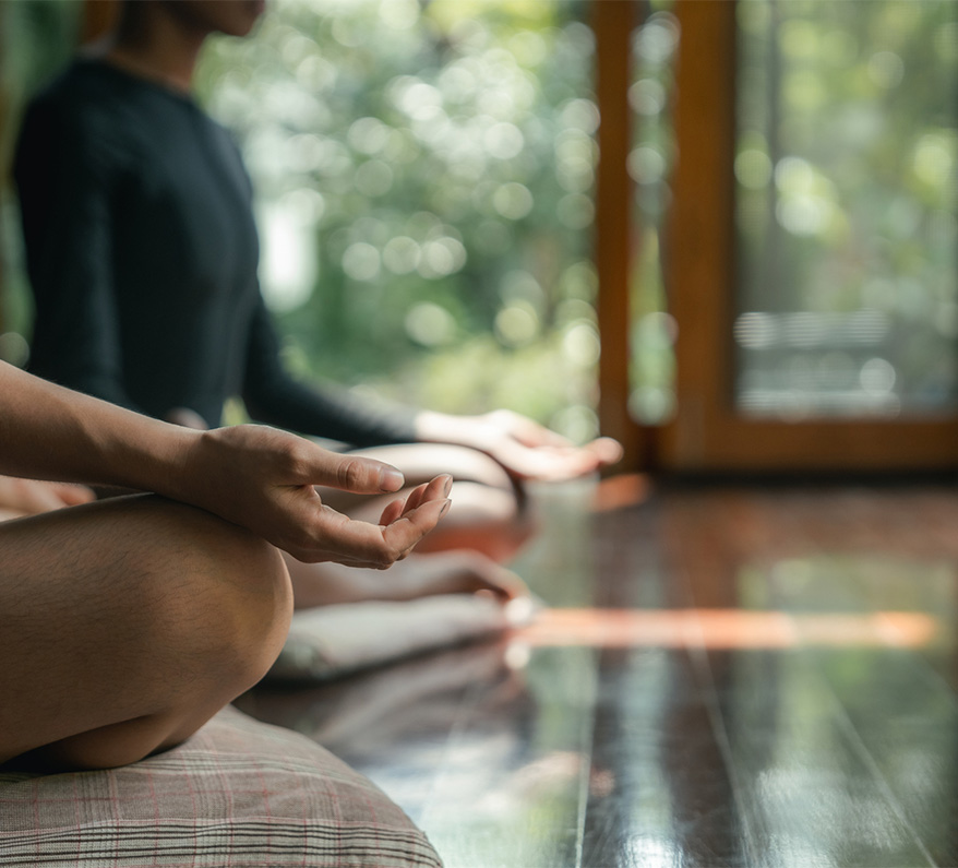 a person sitting on a floor with their hands in the air