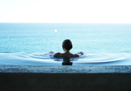 a woman in a pool with a body of water