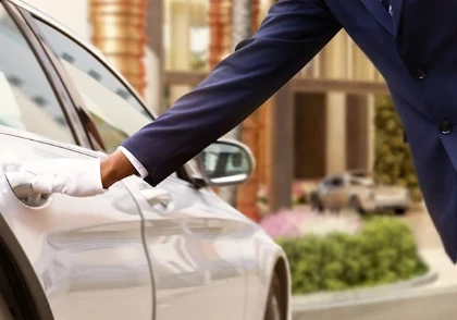 a person's hand reaching out to a car