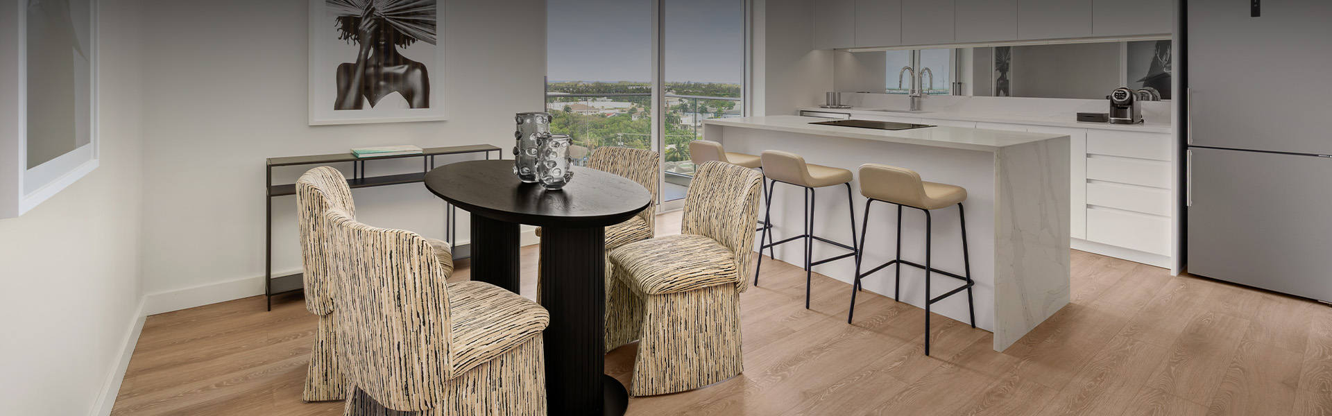 a table with chairs in a room with a view of a city