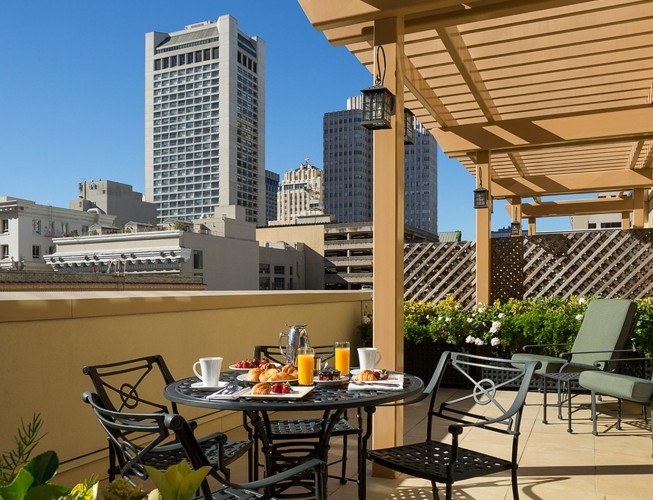 A rooftop patio with a breakfast table and city view