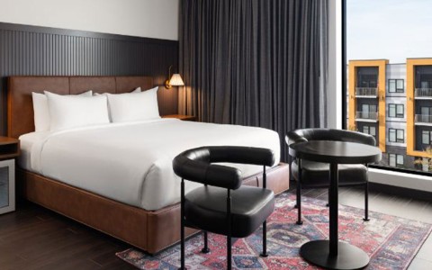 a bed with a round table and chairs in a room