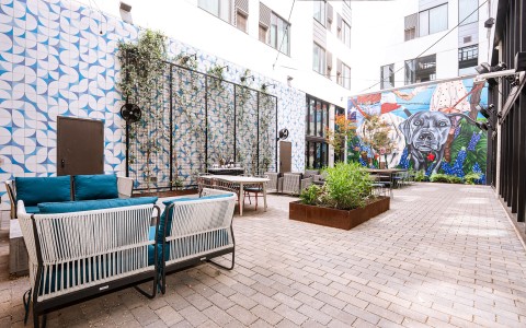 a patio area with chairs and tables and plants