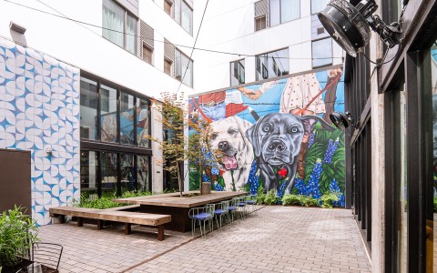 a mural of dogs on a wall in a courtyard