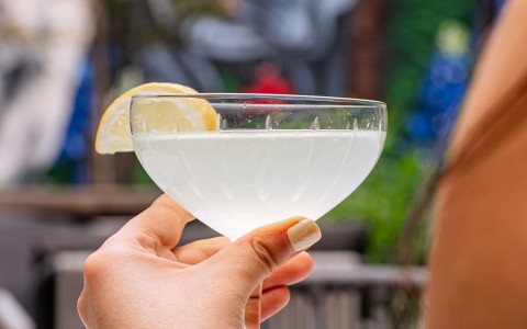 a hand holding a glass of liquid