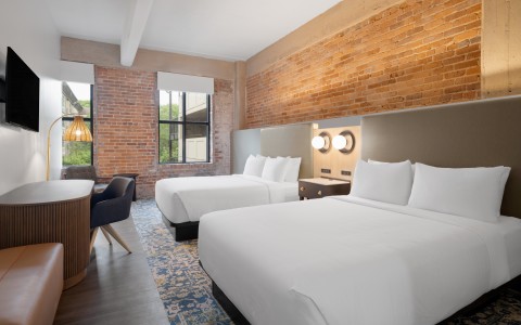 a room with two beds and a desk