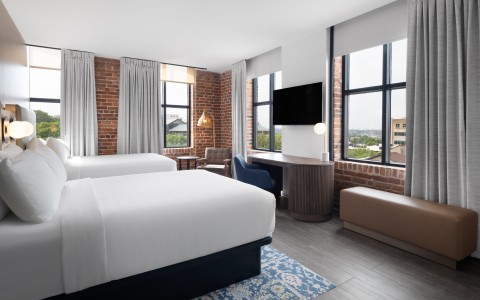 a room with two beds and a brick wall