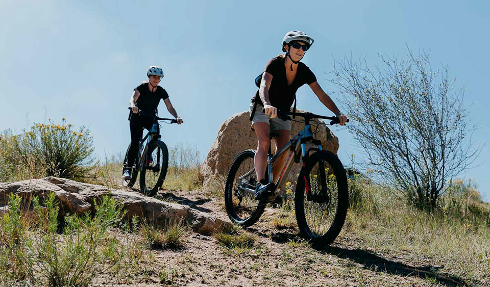 a group of people riding bikes on a rocky hill