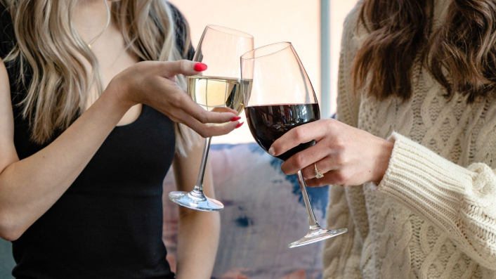 a pair of hands holding wine glasses