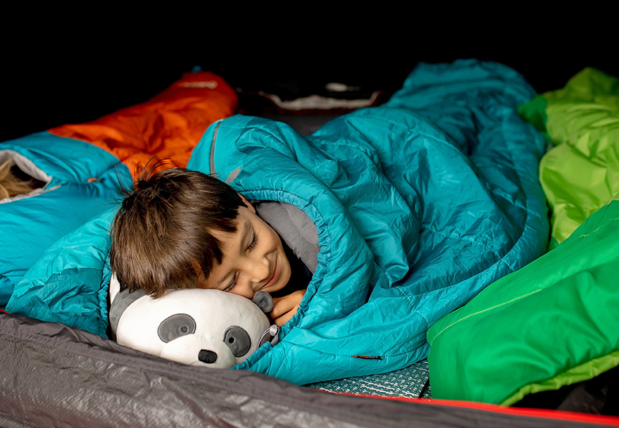 a boy sleeping in a sleeping bag