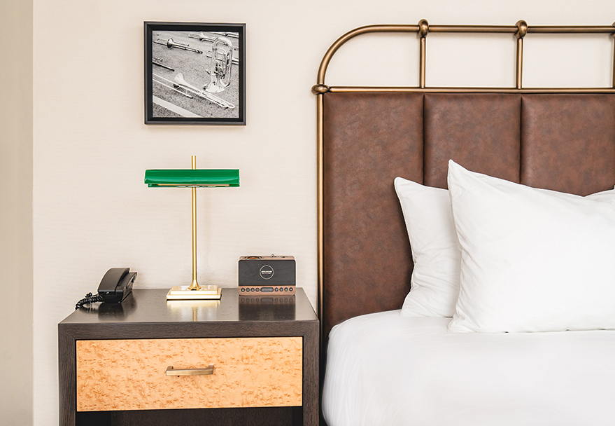 a bed with a lamp and a phone on a table