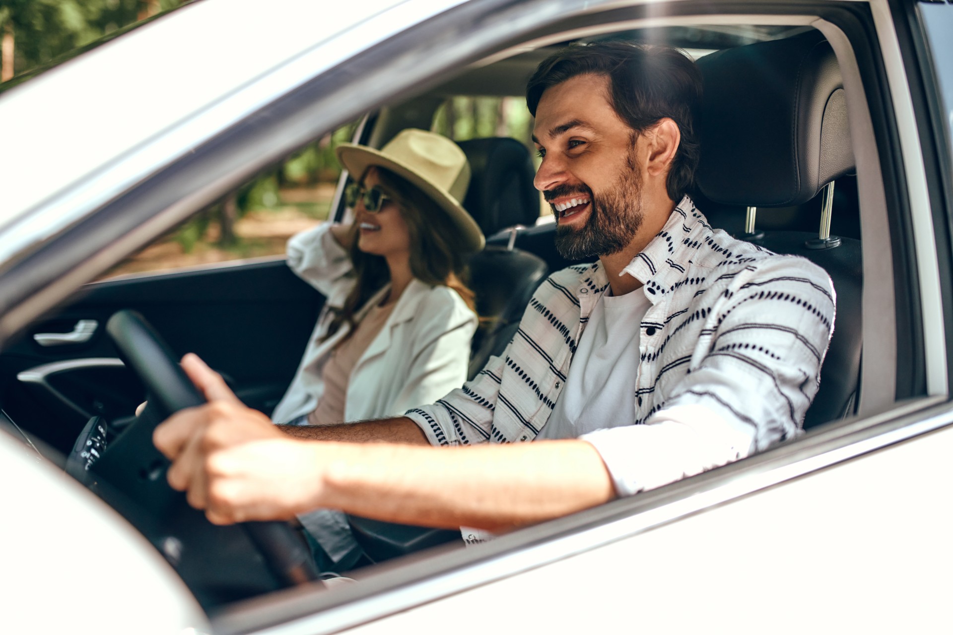 a man and woman driving a car