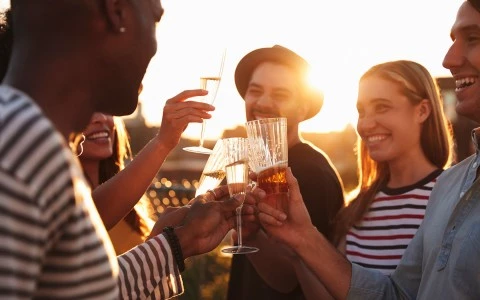 group of friends holding glasses together for a toast