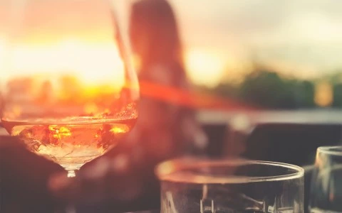 wine glass on a table with the sun gleaming in background