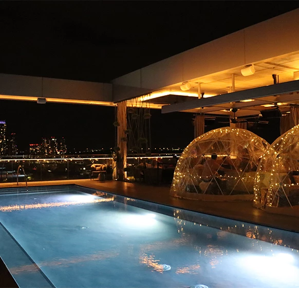 a pool with lights and dome tents